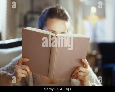 Closeup on woman at home in sunny winter day reading book. Stock Photo