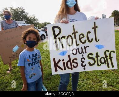 Viera, United States. 30th Aug, 2021. People demonstrate with placards outside an emergency meeting of the Brevard County, Florida School Board in Viera to discuss whether face masks in local schools should be mandatory. An executive order signed by Florida Governor Ron DeSantis banning mask mandates in schools was thrown out by a Florida judge on Friday. Credit: SOPA Images Limited/Alamy Live News Stock Photo