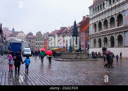 POZNAN, POLAND - Nov 29, 2017: The people walking on the old city square with a Christmas tree on a rainy day Stock Photo