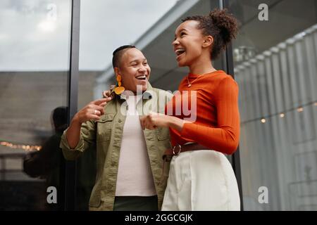 Waist up portrait of two young women laughing carefree white enjoying outdoor party at rooftop Stock Photo