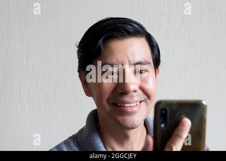 Hispanic man using his cellphone Stock Photo