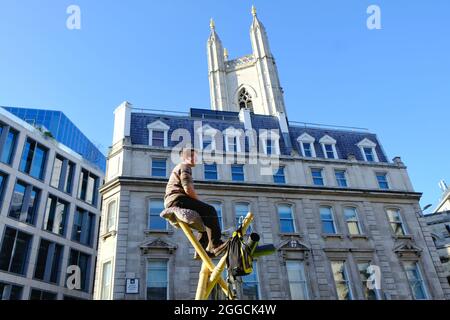 London, UK. Extinction Rebellion protesters sit atop bamboo structures blocking Cannon Street during the 'Blood Money' march targetting the City. Stock Photo