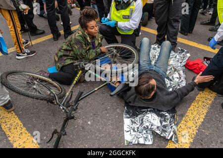 London, UK. 30th Aug, 2021. Two protesters seen locked together during the Extinction Rebellion's The Impossible Tea Party protest against the lack of action to the climate crisis. Credit: SOPA Images Limited/Alamy Live News Stock Photo