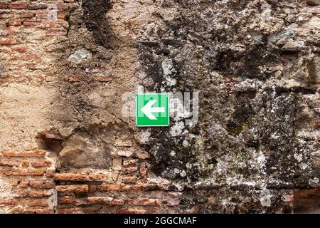 arrow sign on an old brick wall Stock Photo