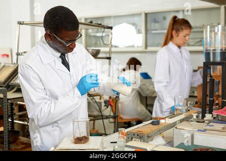 Focused male lab scientist in glasses working with different reagents Stock Photo