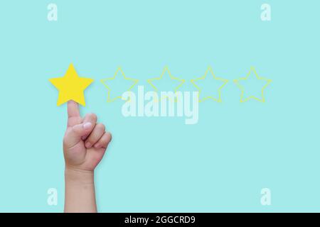 Hand click star rating on blue background. Concept of satisfaction customer service. Stock Photo