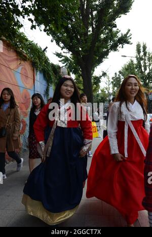 Chinese tourist dressed in traditional Korean clothing walking in the streets of Bukchon Hanok in Seoul, Korea. Stock Photo