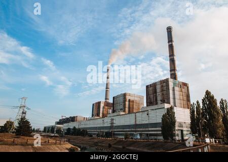 Air pollution, factory pipes, smoke from chimneys on sky background. Concept of industry, ecology, steam plant, heating season, global warming. Stock Photo