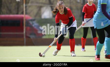 Teenage field hockey player in attack with ball Stock Photo