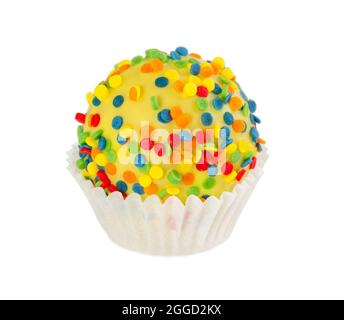 Cake ball in yellow glaze with colorful sprinkles in paper form isolated on white background Stock Photo