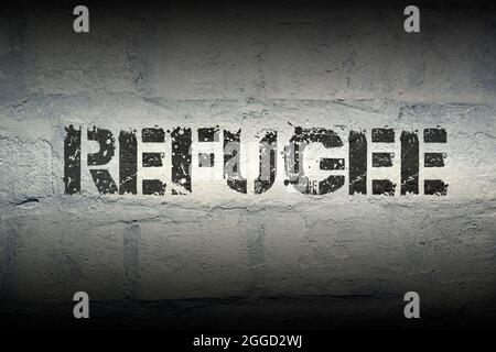 refugee stencil print on the grunge white brick wall Stock Photo