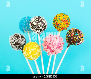Different colorful cake pops on blue background Stock Photo
