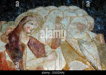 Saint with clenched fist amid group of armoured soldiers, one of them wielding a lance or spear.  Detail close view of Late Medieval fresco in the Duomo di Santa Maria Assunta (Cathedral of the Assumption of Our Lady) at Bolzano / Bozen, South Tyrol, Trentino-Alto Adige, Italy. Stock Photo