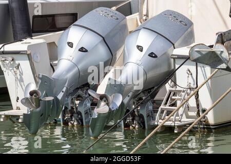 Pair gray marine engines outboard model Honda 250 mounted on a white fiberglass pleasure boa moored at harbor,Rome,Italy - August 27, 2021 Stock Photo