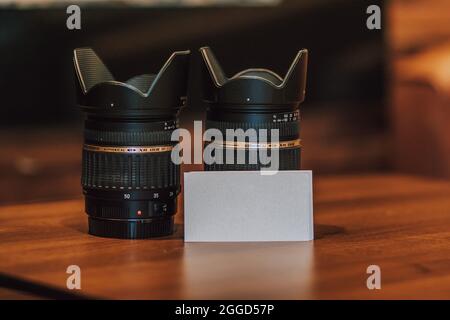 Blank Empty White Business Cards Next to Camera Lenses Stock Photo