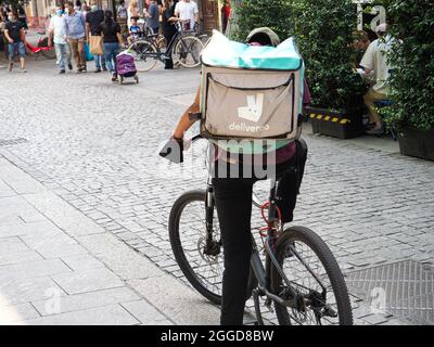 MILAN, ITALY - Aug 08, 2021: A 'Deliveroo' food delivery rider on a crowded street in Milan, Italy Stock Photo