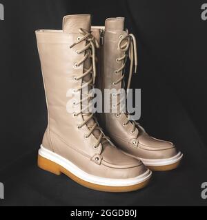 Light brown wellington boots on a black background. Women shoes close-up photo Stock Photo