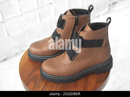 Brown women boots. Female autumn and winter footwear on a wooden stand. Modern design Stock Photo