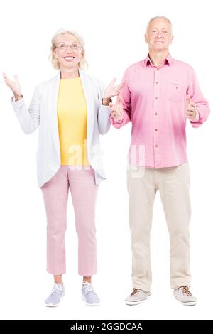 Vertical full length shot of modern senior Caucasian man and woman in love standing together, white background Stock Photo