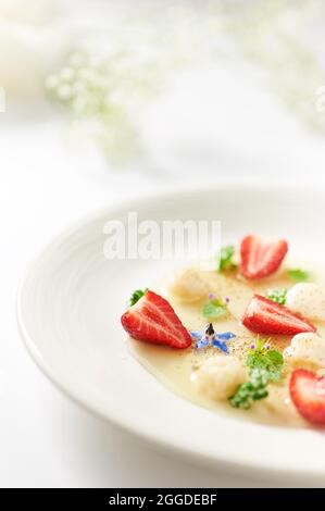 Yogurt and ginger ball in vervain sauce garnished with strawberry and coffee Stock Photo