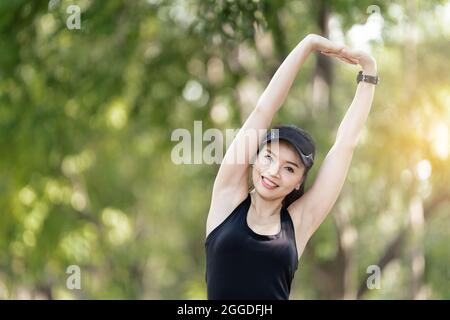 Cheerful Southeast Asian Female Runner In Sports Attire Do Some Stretching  In The City Natural Park Stock Photo - Download Image Now - iStock