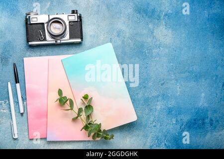 Composition with notebooks, pens and photo camera on color background Stock Photo