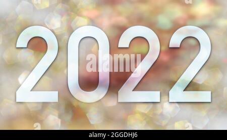 New year 2022, numbers on a background of an image of defocused glittering lights in gold and pink tones. Stock Photo