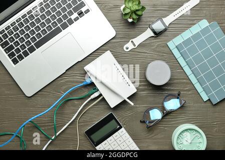 Composition with wi-fi router, laptop, speaker and smart watch on wooden wooden background Stock Photo