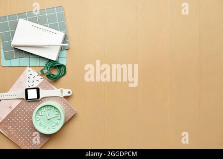 Composition with wi-fi router, smart watch, clock and stationery on color background Stock Photo