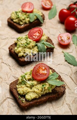 Tasty sandwiches with guacamole and tomato on table Stock Photo