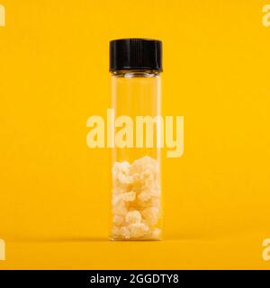 a pieces of pure hash dab crystal cannabis on yellow background. Stock Photo