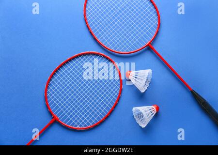 Badminton rackets and shuttlecocks on color background Stock Photo