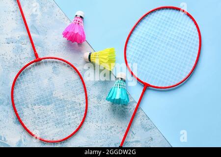 Badminton rackets and shuttlecocks on color background Stock Photo