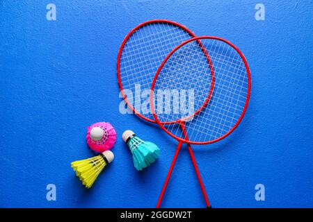 Badminton rackets and shuttlecocks on color background Stock Photo