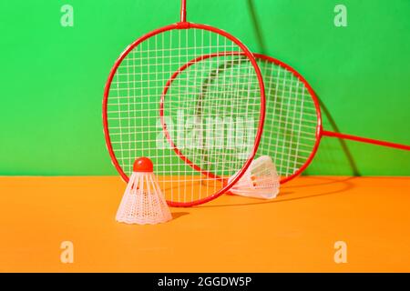 Badminton rackets and shuttlecocks on color background Stock Photo