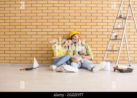 Young couple with cute dog resting during repair in their new house Stock Photo