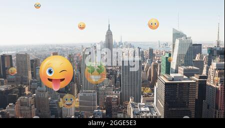 Image of emoji icons flying up over cityscape Stock Photo