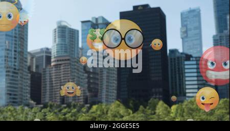 Image of emoji icons flying up over cityscape Stock Photo