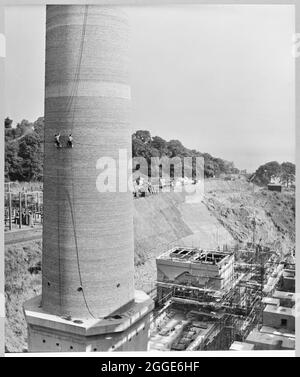 A view from the boiler house roof towards chimney no.1 on the construction site of Portishead 'B' Power Station, showing two Laing workers repointing the chimney's brickwork. Portishead B Power Station opened in the mid 1950’s. Portishead's original power station, which was completed in 1929, became known as Power Station 'A'. Portishead B was built on part of the Great Western Railway’s original Portishead Railway Station, which was demolished and rebuilt closer to the centre. Portishead B had eight coal-fired and four oil-fired steam boilers. The power station closed in 1982, a Stock Photo