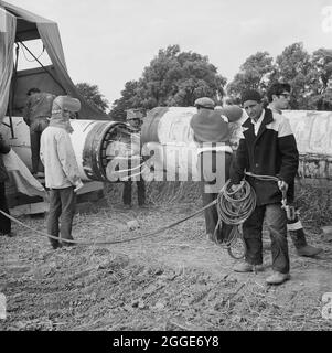 A team of men working on the lining up operation of the Fens gas pipeline, showing the internal pneumatic clamp for locking steel pipes together. Work on laying the Fens gas pipeline started in June 1967 and was a joint venture between Laing Civil Engineering and French companies Entrepose and Grands Travaux de Marseille (GTM) for the Gas Council. Over 600 men worked on the project to lay 36 inch diameter steel pipes starting at West Winch in Norfolk and running to where it linked up with the next contract at Woodcroft Castle in Cambridgeshire. The pipeline crossed four rivers and numerous dyk Stock Photo
