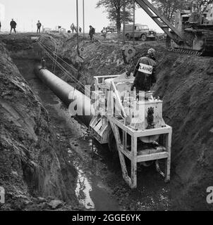 A view of thrust boring being carried out during the installation of the Fens gas pipeline. Work on laying the Fens gas pipeline started in June 1967 and was a joint venture between Laing Civil Engineering and French companies Entrepose and Grands Travaux de Marseille (GTM) for the Gas Council. Over 600 men worked on the project to lay 36 inch diameter steel pipes starting at West Winch in Norfolk and running to where it linked up with the next contract at Woodcroft Castle in Cambridgeshire. The pipeline crossed four rivers and numerous dykes and ditches. Stock Photo