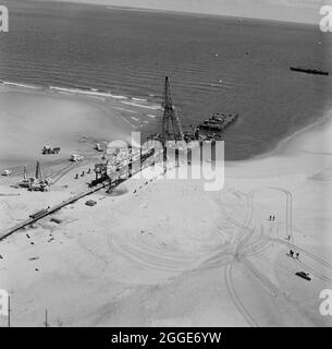 An aerial view of the launch site of the North Coates pipeline, showing the pipeline, a cofferdam, floating sheerleg with accompanying tug and a header barge. The civil engineering work on the North Coates oil pipeline was carried out by Laing Pipelines along with French companies Entrepose and GTM, and the main contractor for the dredging work was Dredging and Construction Company along with Adriaan Volker of Rotterdam. The launch of the pipeline took place at 12.30 on 16th June 1970 and took 3hrs to complete. At this time, it was the largest sea pipeline to be placed off the British coast. T Stock Photo