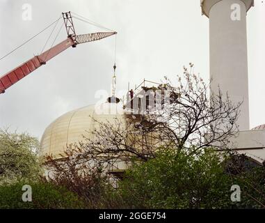 London Central Mosque and The Islamic Cultural Centre, Park Road, Regent's Park, City of Westminster, Greater London Authority, 15/03/1977. View of London Central Mosque from the north-east, showing a crane lowering the crescent finial onto the golden domed roof of the main prayer hall. This image was catalogued as part of the Breaking New Ground Project in partnership with the John Laing Charitable Trust in 2019-20. Stock Photo