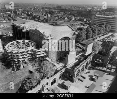 A view from the spire of the Cathedral Church of Saint Michael, looking in a north-east direction over the construction site of the new Coventry Cathedral, with the ruins of the old cathedral in the foreground and the city of Coventry beyond. The photograph shows the construction of the new Coventry Cathedral, designed by Basil Spence in 1951 and constructed between the mid-1950s and 1962. It replaced the ruined Cathedral Church of St Michael which had been badly damaged by bombing in 1941. The photograph was taken to show progress on the construction of the cathedral including the concrete ro Stock Photo