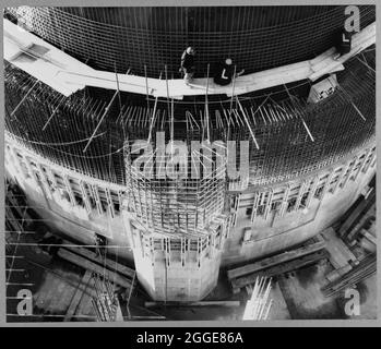 Looking down at the east side of Reactor No.1 during the construction of Berkeley Nuclear Power Station, showing the biological shield and its discharge shaft with a Laing team working above. Berkeley Nuclear Power Station was the first commercial nuclear power station in the United Kingdom and one of the first generation of nuclear reactors in Britain. It had two Magnox reactors and was one of four stations located close to the mouth of the River Severn and the Bristol Channel. Laing were the civil engineers for the project with work commencing on 7th January 1957. The nuclear power station c Stock Photo