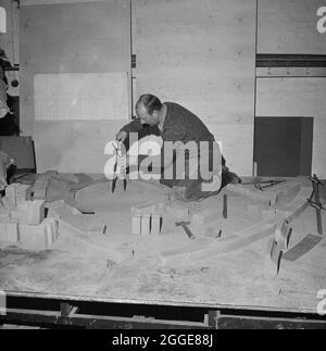 A stonemason measuring and laying out blocks of stone on a template for the restoration of a window at Carlisle Cathedral. This photograph is part of a batch taken by Laing to show restoration work being carried out using SBD Certite. In 1961, N M Phillips, the architect for Carlisle Cathedral started experimenting with the bonding material SBD Certite in the restoration of the cathedral. It was used on all but one of the decorated Gothic windows of the South Clerestory and by the time this photograph was taken, it was being used in the restoration of the north face of the cathedral. By using Stock Photo