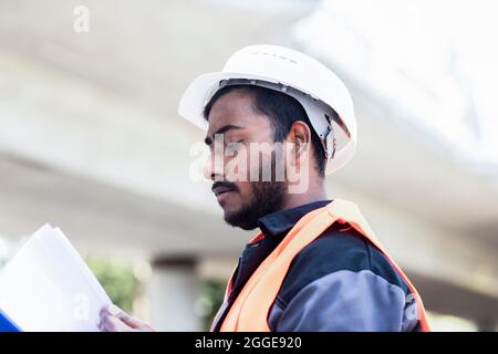 Young technician with beard outside with helmet working on a bridge, Baden-Wuerttemberg, Germany Stock Photo