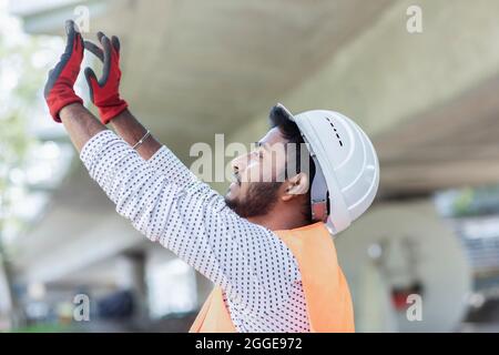 Young technician with beard working outside with helmet, Baden-Wuerttemberg, Germany Stock Photo