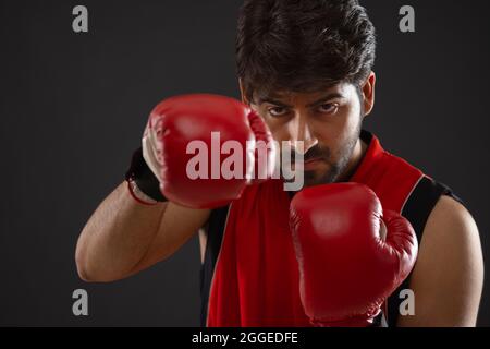 PORTRAIT OF A BOXER PRACTICING MOVES IN FRONT OF CAMERA Stock Photo