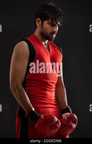 PORTRAIT OF A CONFIDENT BOXER STANDING WHILE READY TO FIGHT Stock Photo